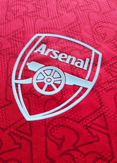Back view showing the Arsenal crest in white with a red background pattern.