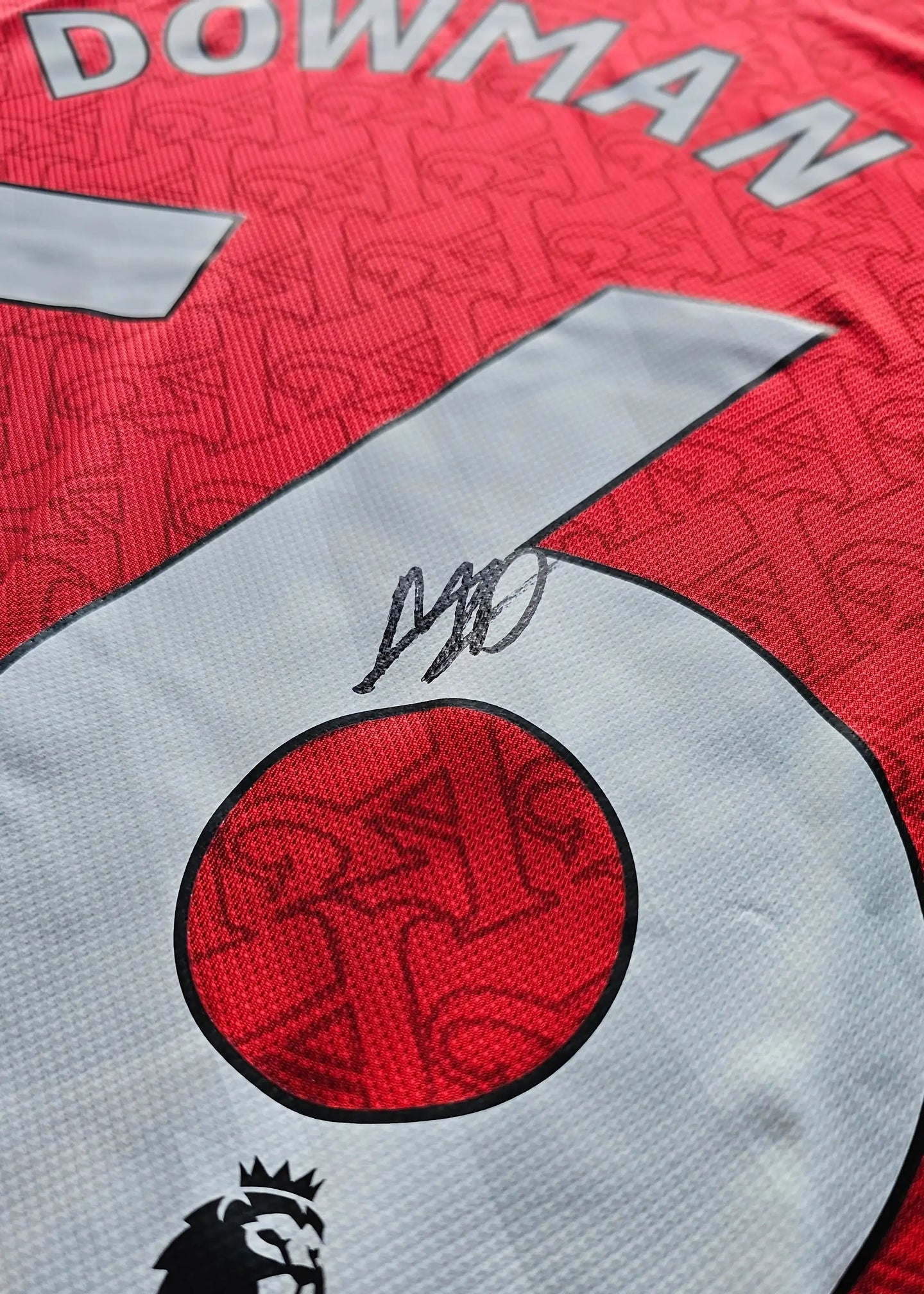 Close-up of signature and No. 56 on the red Arsenal football shirt with Dowman name visible.