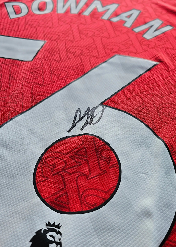 Close-up of signature and No. 56 on the red Arsenal football shirt with Dowman name visible.