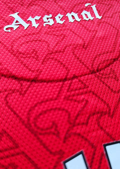 Back view highlighting 'Arsenal' in white lettering against a textured red background.