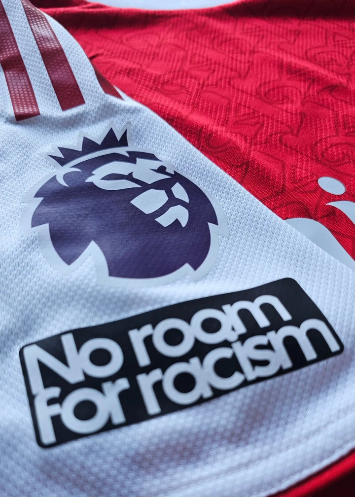Close-up of a red football shirt featuring the Premier League lion crest and &
