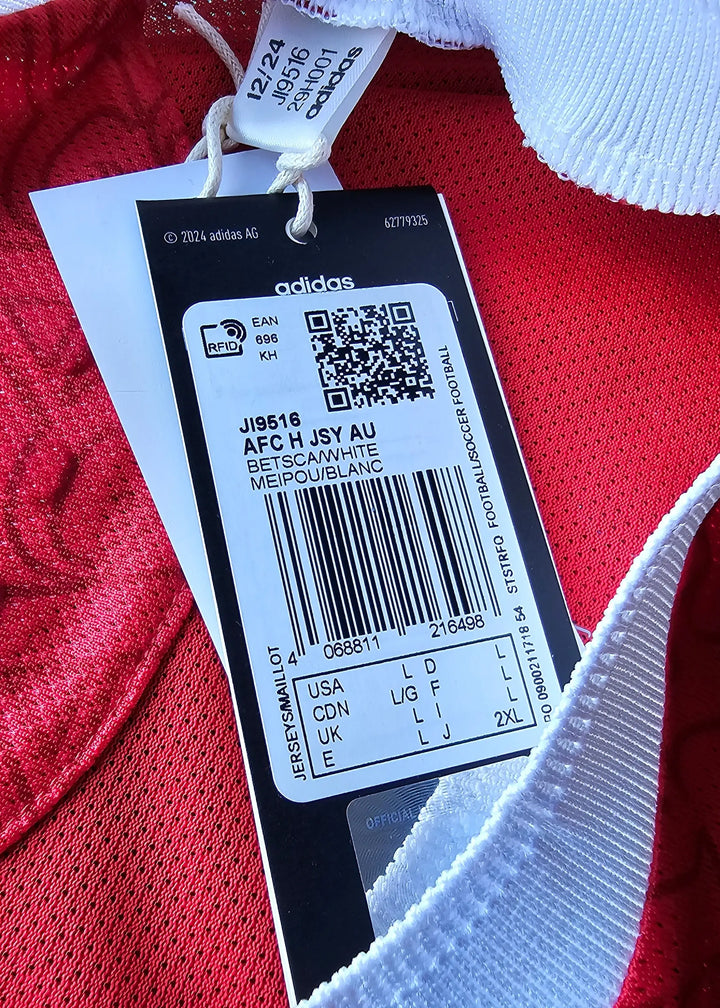Close-up of care label with size details for Max Dowman 56 football shirt from Arsenal.