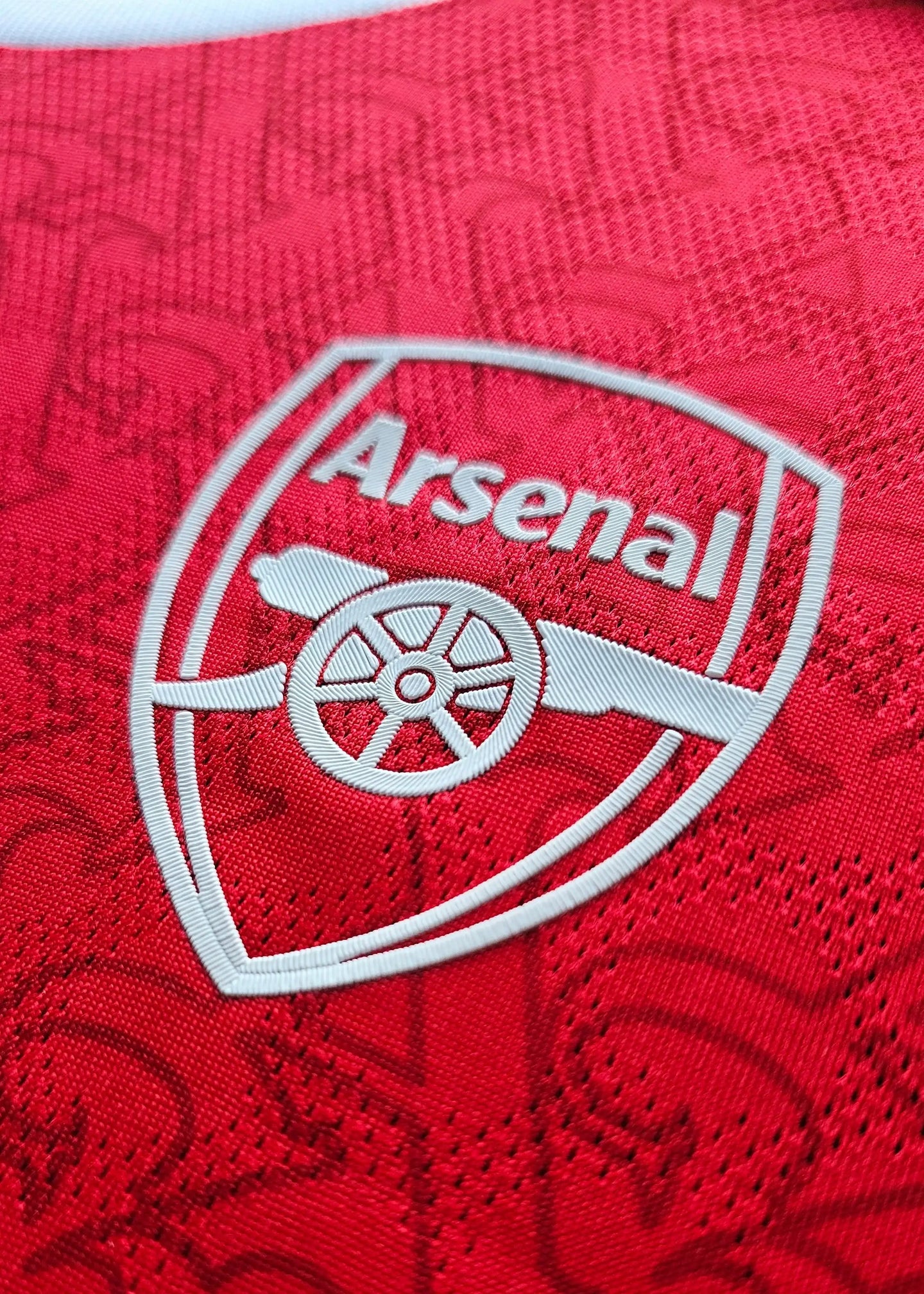 Crest detail featuring the Arsenal emblem in white on a red background.