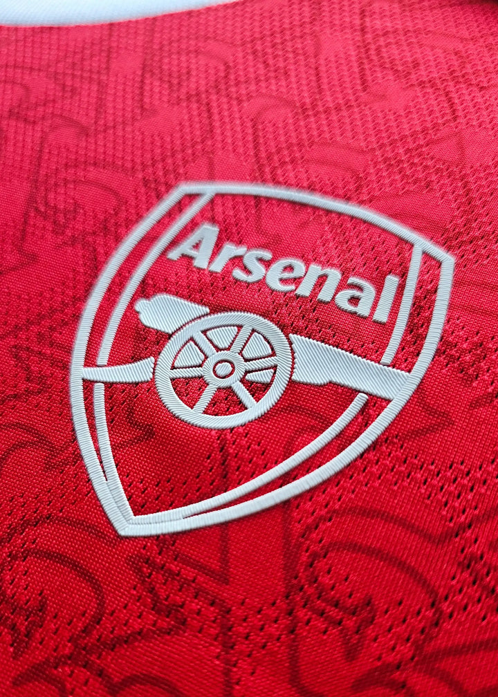 Crest detail featuring the Arsenal emblem in white on a red background.