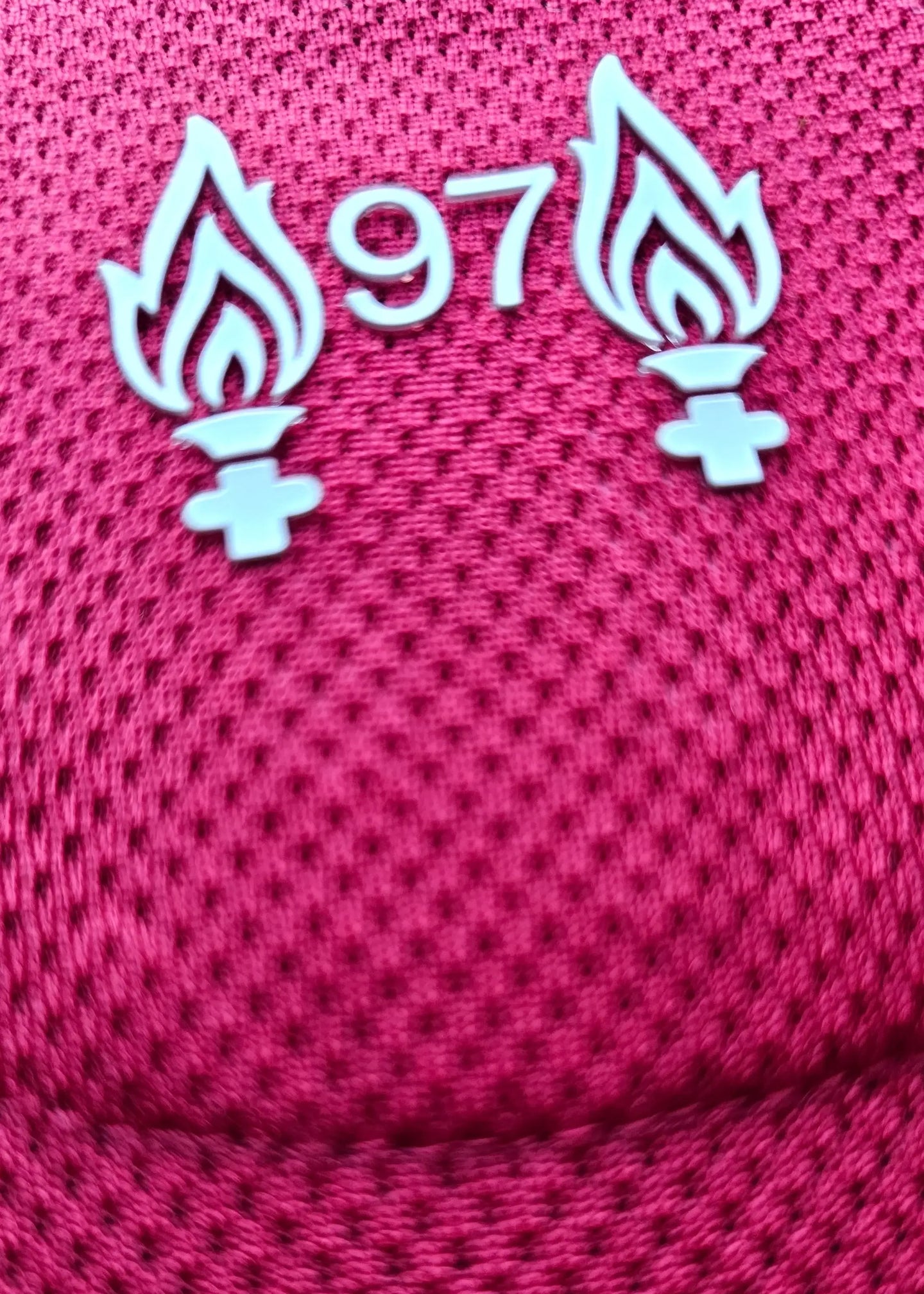 Detail view showing the No. 97 with two flames emblem on a red football shirt.