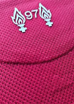 Close-up of Liverpool F.C. shirt displaying the '97' emblem with flames on a red textured background.