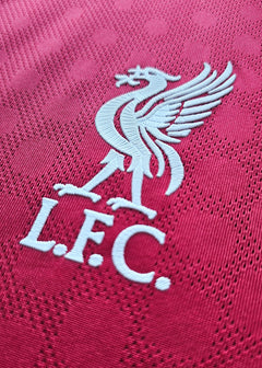 Close-up of Liverpool crest featuring a white Liver bird and L.F.C. on a red background.