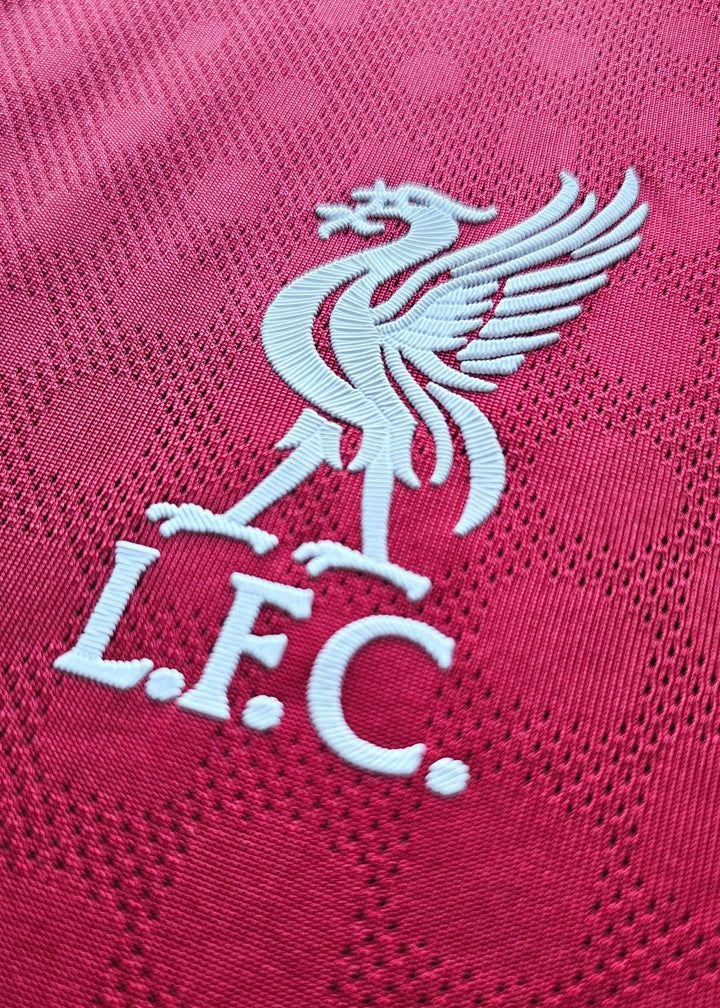 Close-up of Liverpool crest featuring a white Liver bird and L.F.C. on a red background.