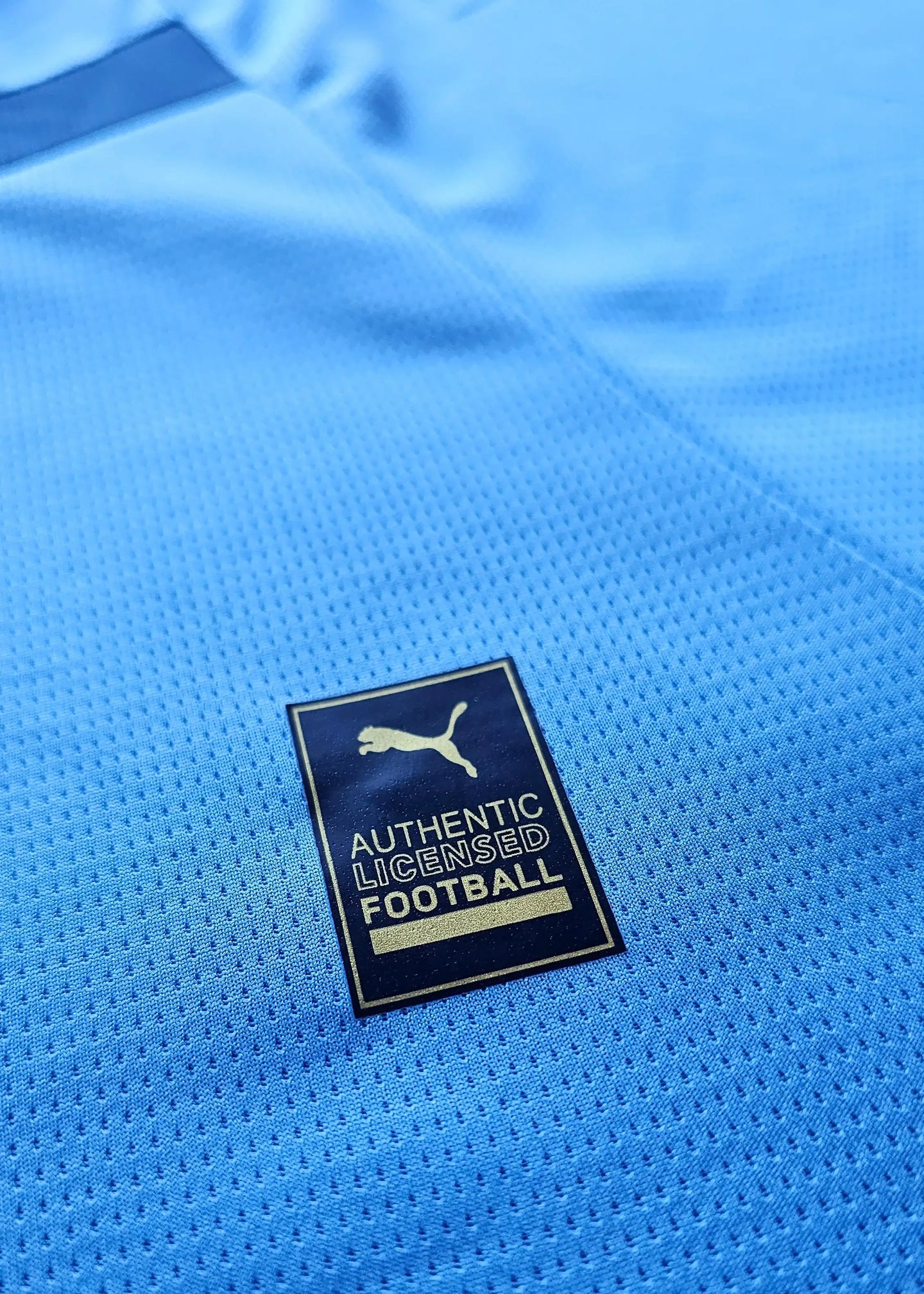 Crest detail showing the Puma logo with AUTHENTIC LICENSED FOOTBALL text on a blue background.