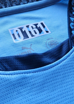 Detail showing '0161' and Puma logo on the collar of a signed football shirt.