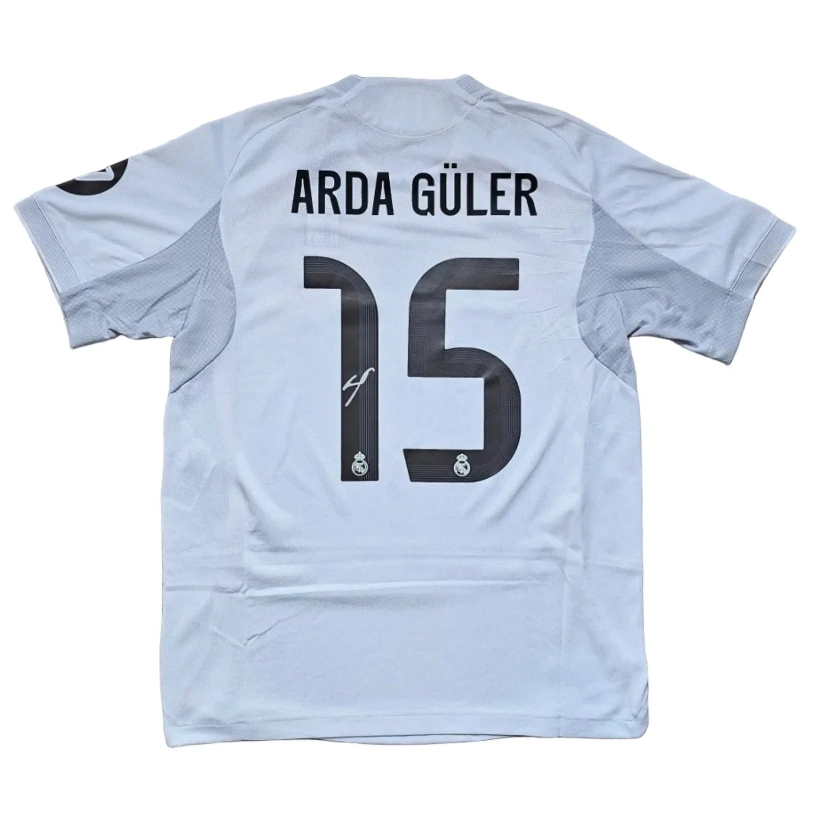 Back view showing Arda Güler, No. 15, and the Real Madrid crest.