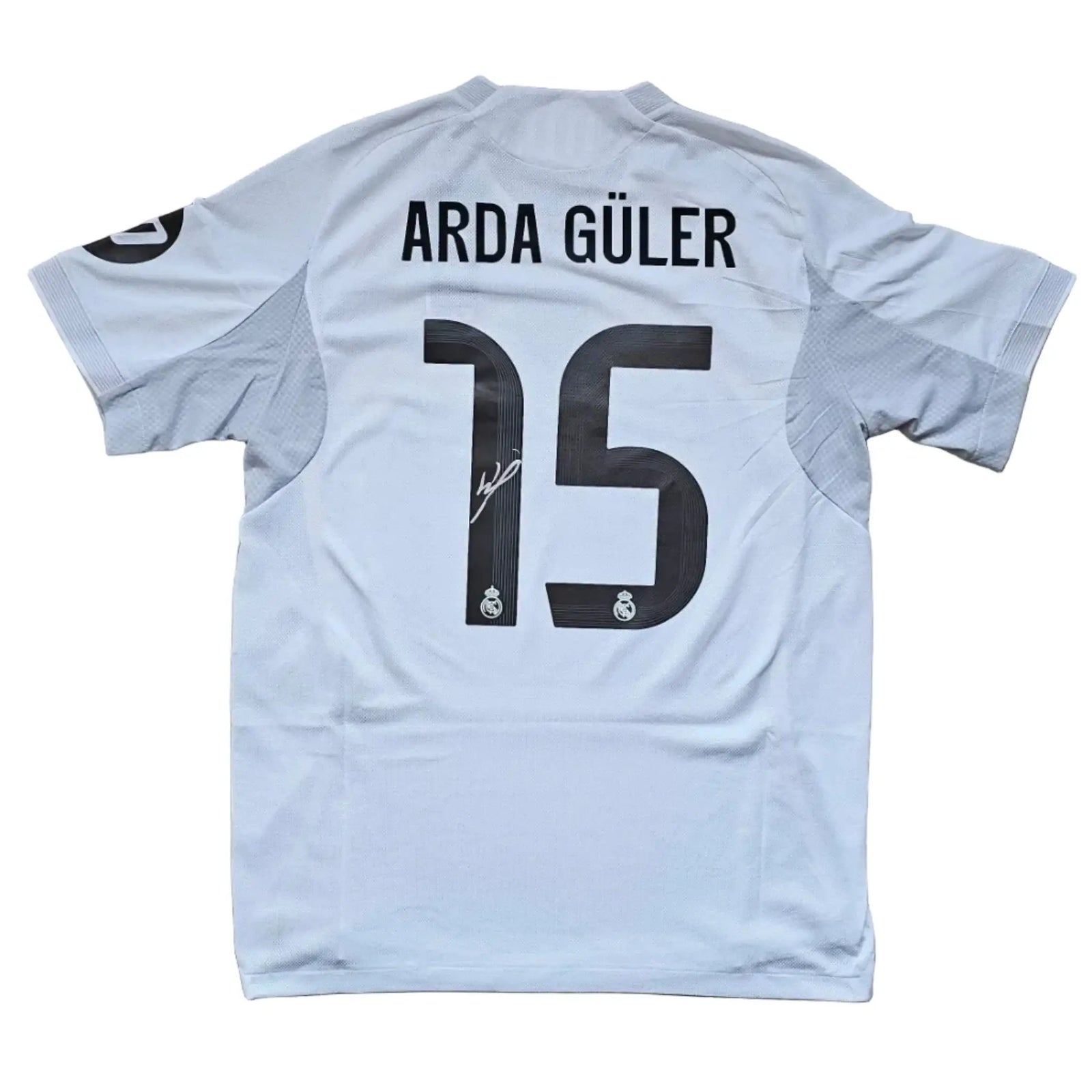 Back view showing Arda Güler, No. 15, and a visible signature on the shirt.