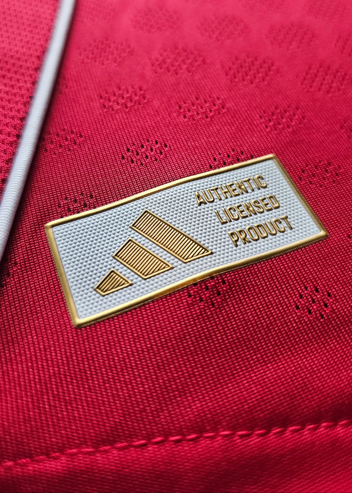 Close-up of 'AUTHENTIC LICENSED PRODUCT' text and adidas logo on red fabric.
