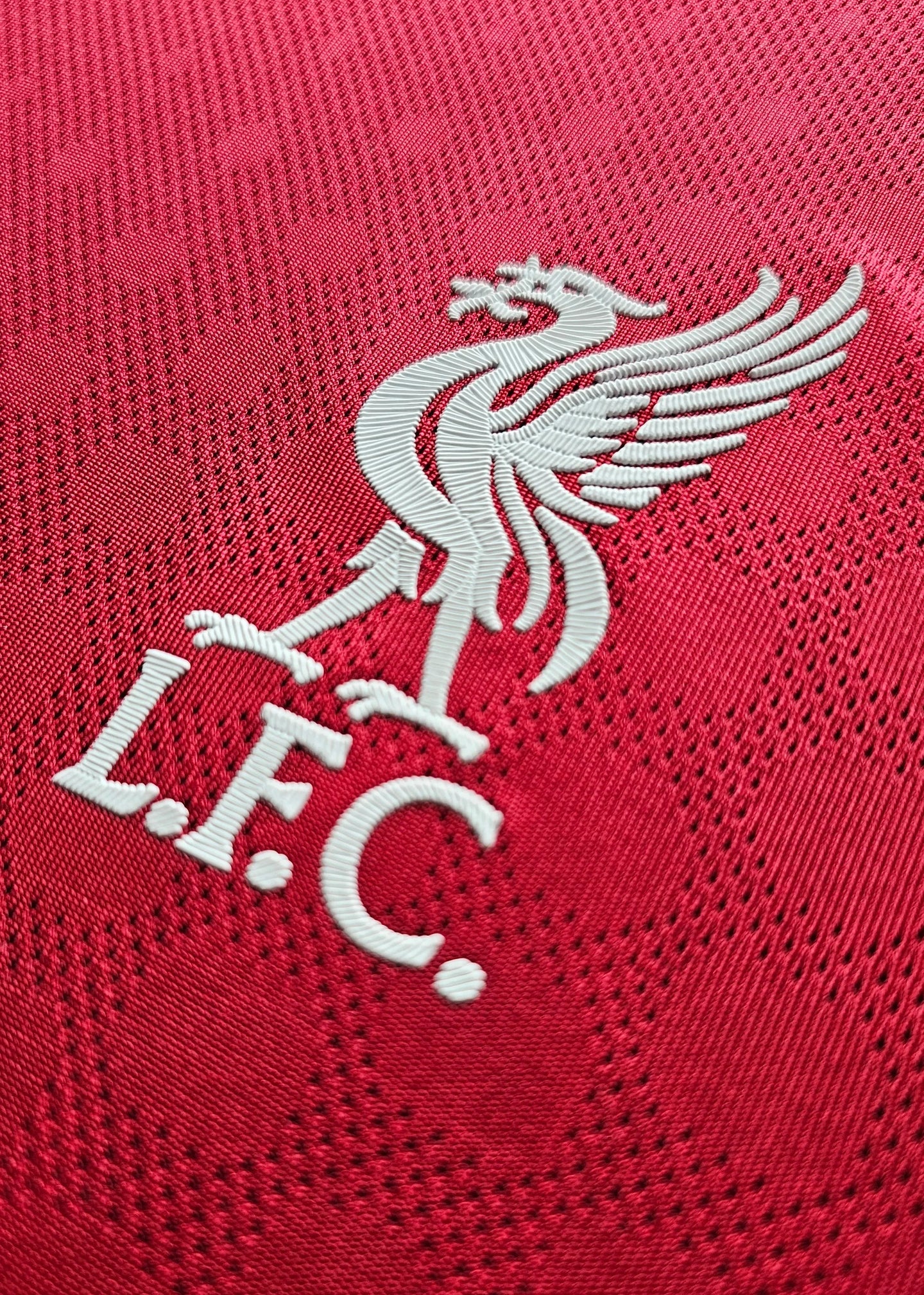 Close-up of the Liverpool F.C. crest featuring the Liver bird and 'L.F.C.' text in white.