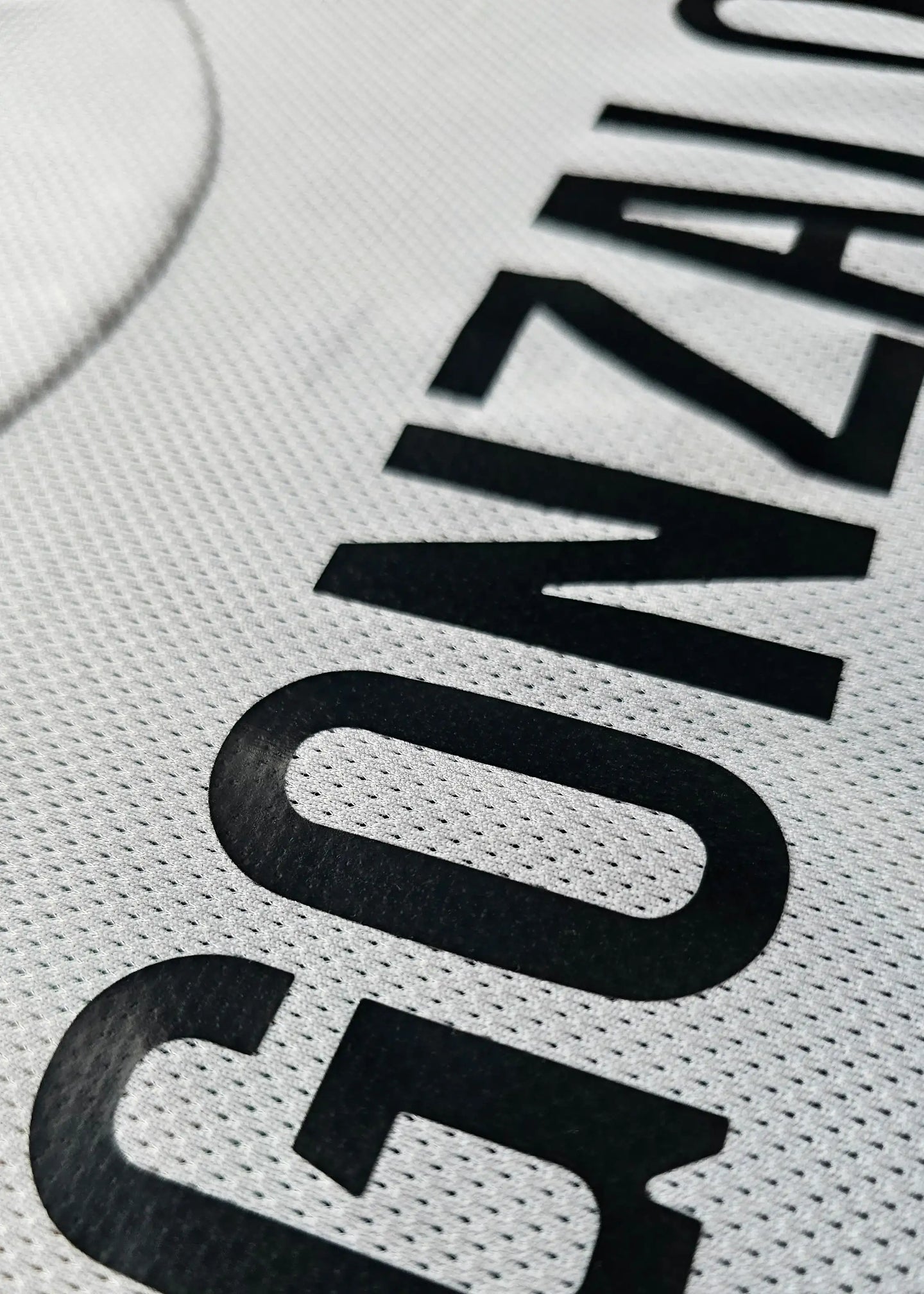 Close-up on the name 'GONZALO' in black lettering on a white shirt.