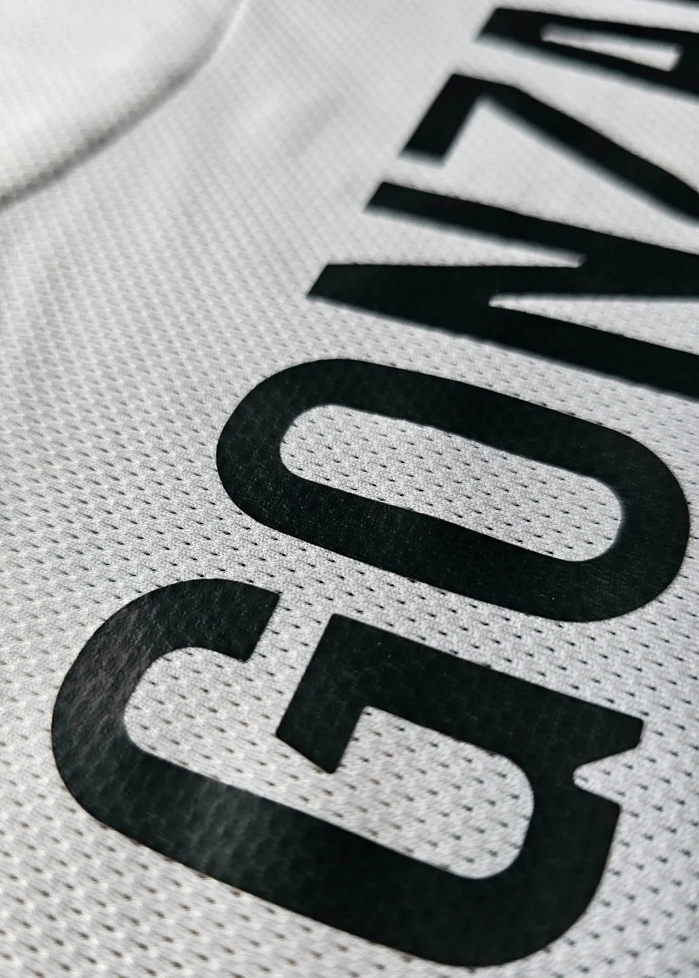 Close-up detail displaying the name 'GONZALO' in bold black letters on a white shirt.
