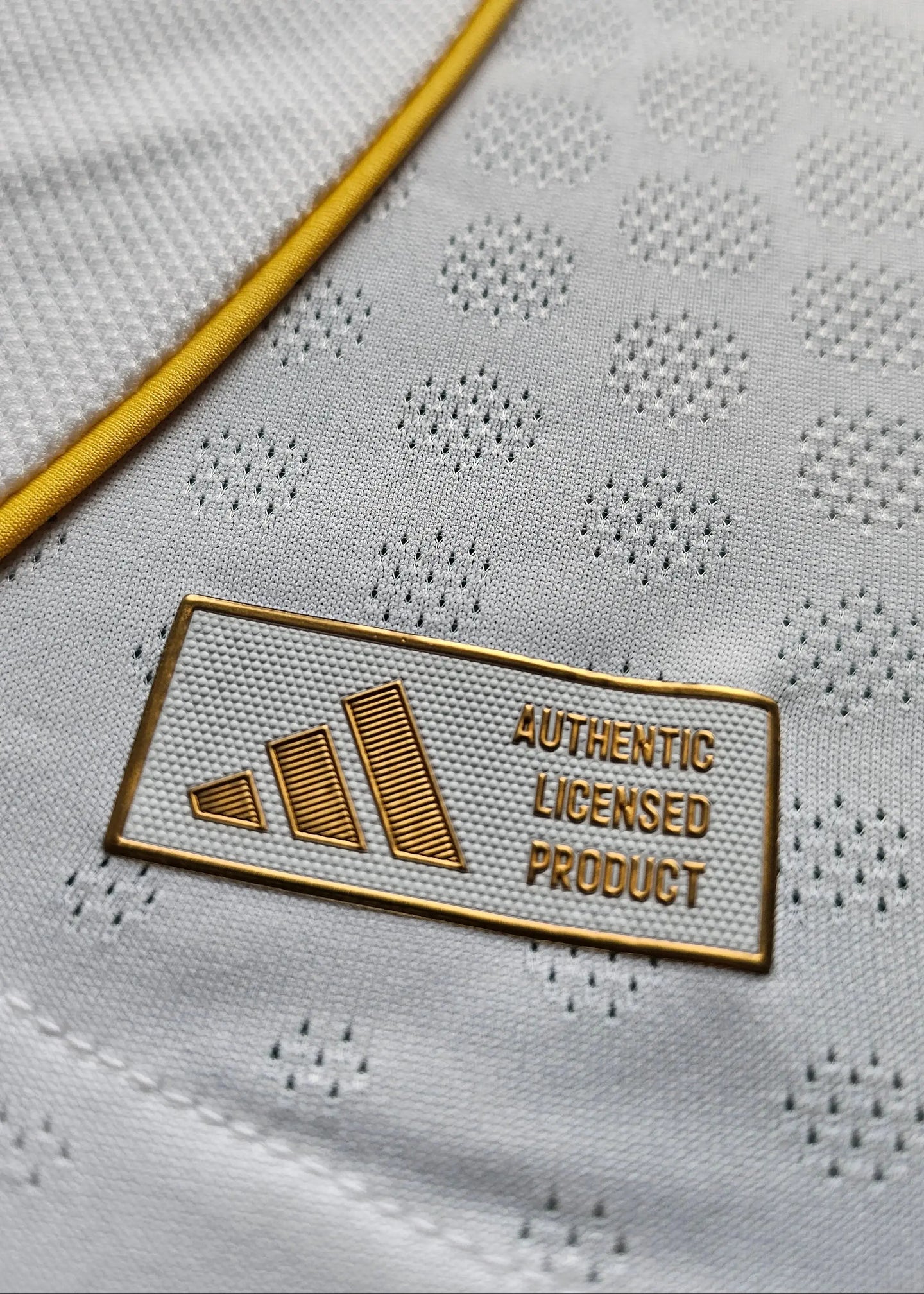 Detail view of the label displaying 'AUTHENTIC LICENSED PRODUCT' on a white fabric with yellow trim.