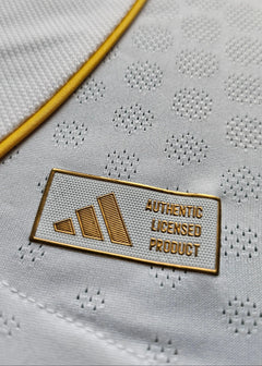 Detail view of the label displaying 'AUTHENTIC LICENSED PRODUCT' on a white fabric with yellow trim.