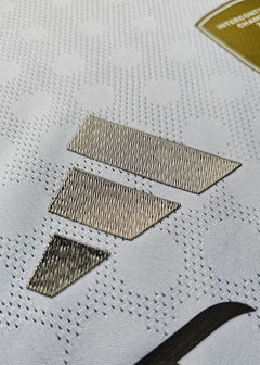 Detail view showcasing the three striped design and textured logo on a white football shirt.