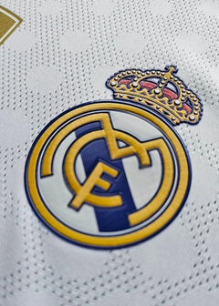 Detailed view of the Real Madrid CF crest with gold crown and blue accents.