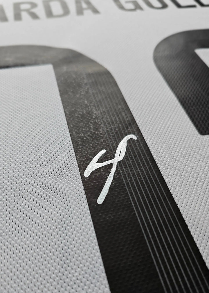 Close-up showing the signature of Arda Güler and the number 15 on a football shirt.