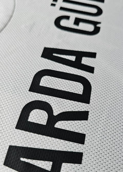 Close-up detail of the name 'Güler' on a white signed football shirt.