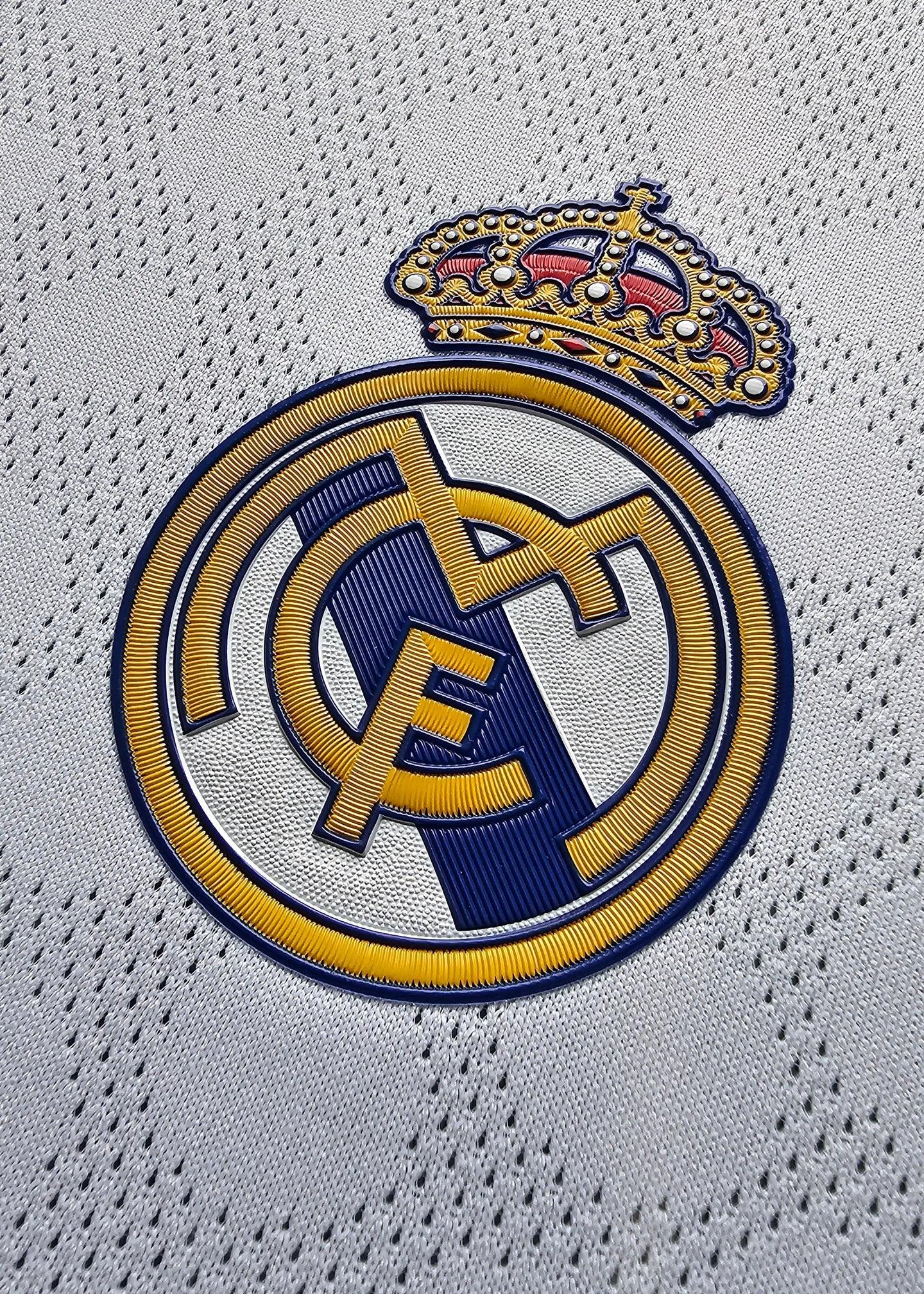 Close-up of Real Madrid crest featuring intricate embroidery and crown detail.