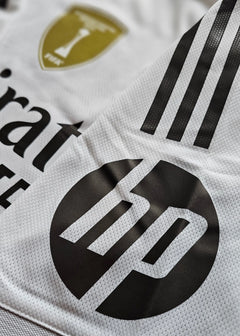 Close-up view showcasing the Real Madrid crest and HP sponsor logo on a white football shirt.