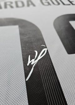 Signature detail of Arda Güler on the number 7 of a white football shirt.