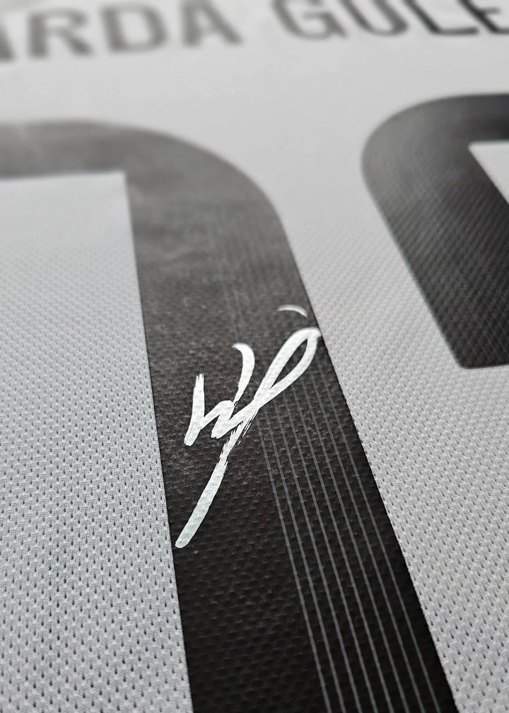 Signature detail of Arda Güler on the number 7 of a white football shirt.