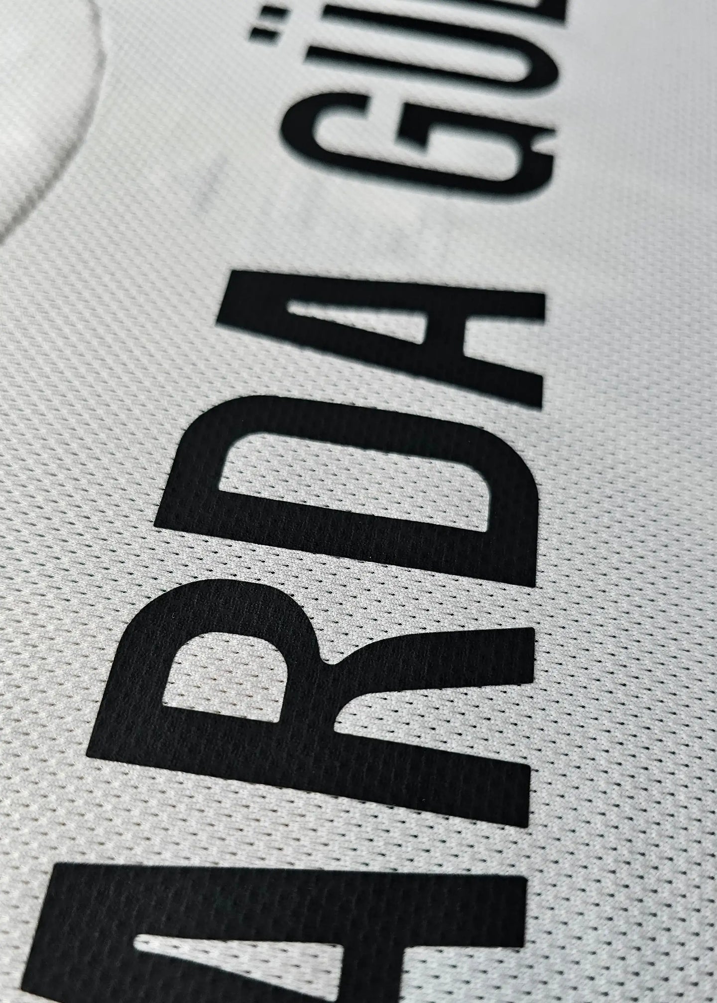 Close-up view showing the name 'ARDA GÜLER' printed in black on a white football shirt.