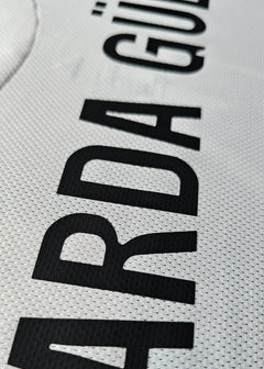 Close-up view showing the name 'ARDA GÜLER' printed in black on a white football shirt.