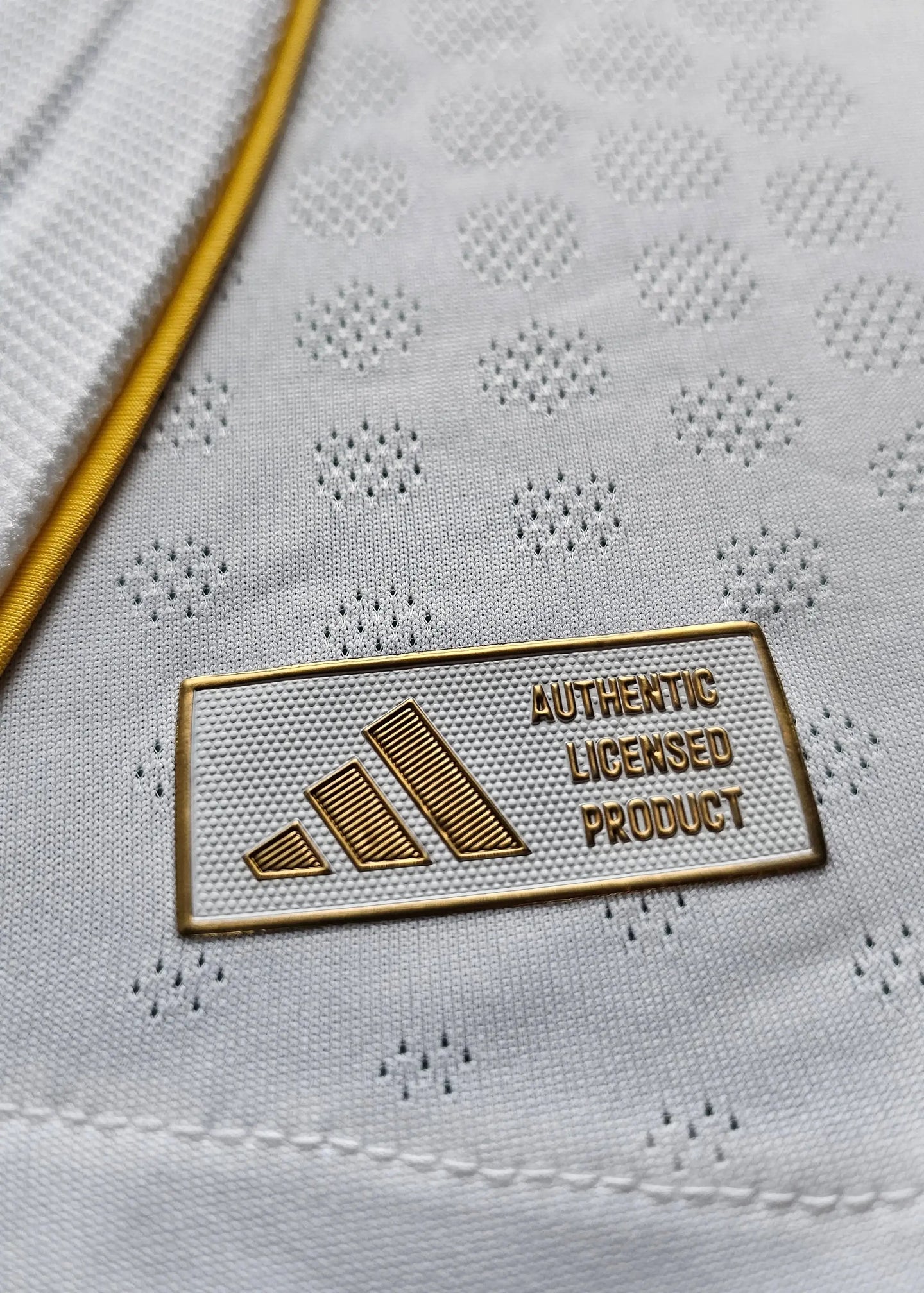Close-up of the label showing 'AUTHENTIC LICENSED PRODUCT' and adidas logo on a white football shirt.