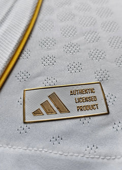Close-up of the label showing 'AUTHENTIC LICENSED PRODUCT' and adidas logo on a white football shirt.