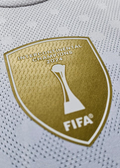 Detail view of FIFA Intercontinental Champions 2024 crest in gold on a white background.