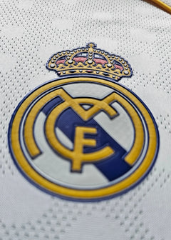 Close-up view of Real Madrid CF crest featuring the crown and yellow detailing.