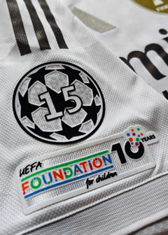 Close-up view showing the UEFA Foundation patch and No. 15 emblem on the white football shirt.