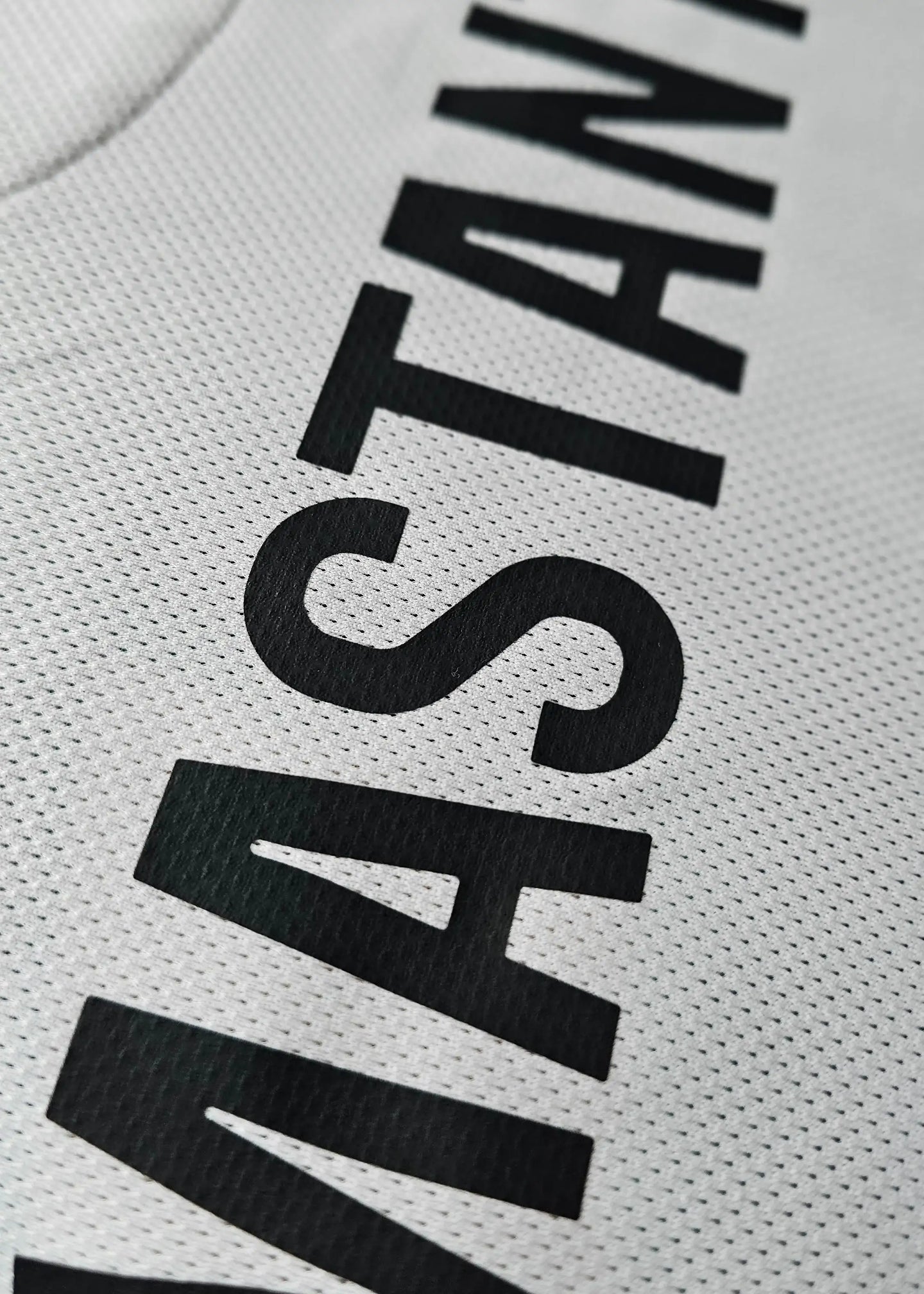 Close-up view of the name 'MASTANTUONO' in black on a signed football shirt.