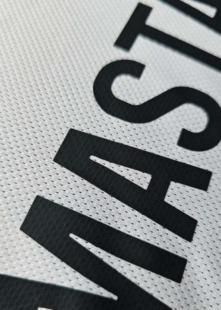 Close-up view of the name MASTANTUONO in black on a textured white football shirt.
