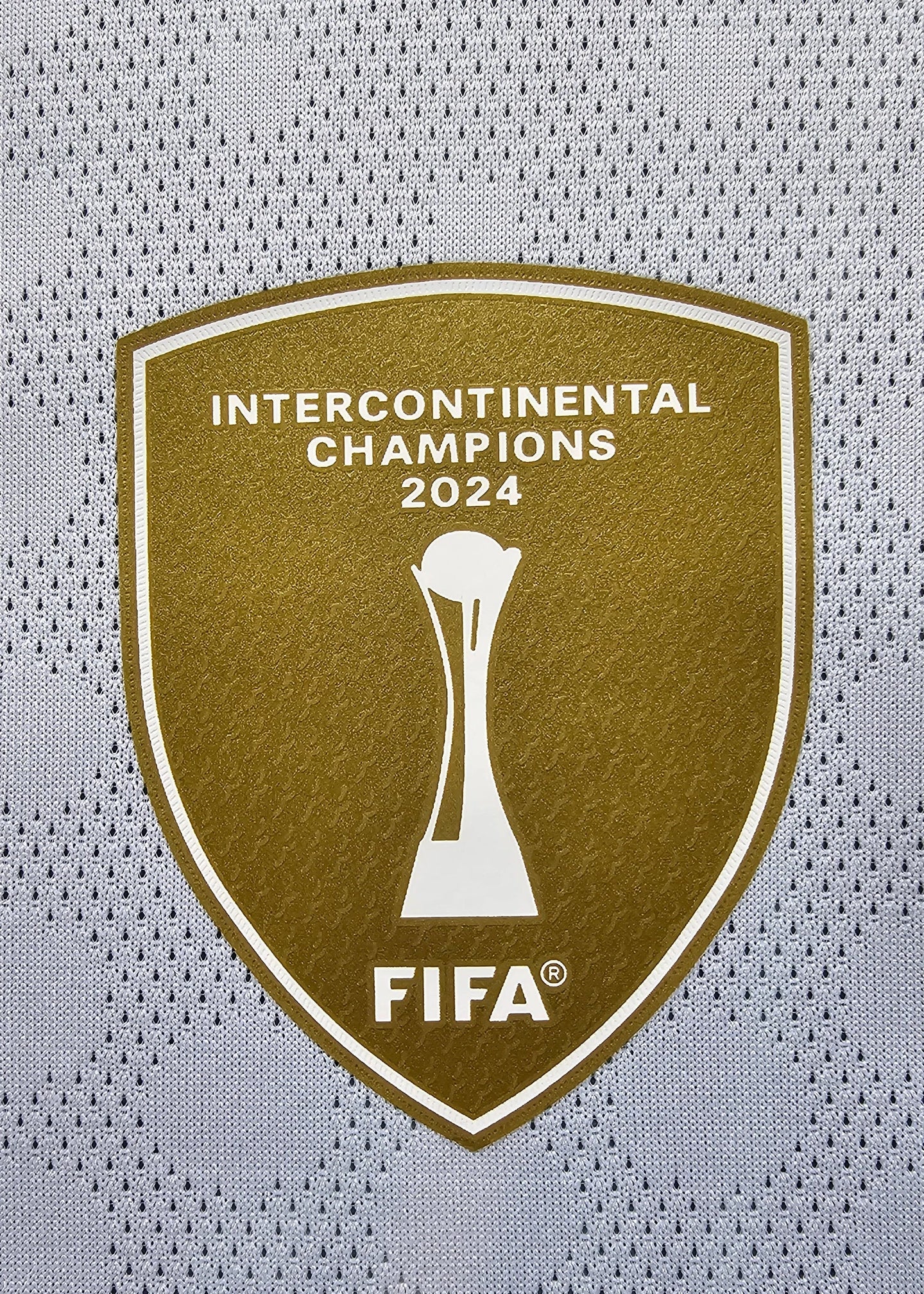 Crest detail featuring Intercontinental Champions 2024 and FIFA logo in gold.