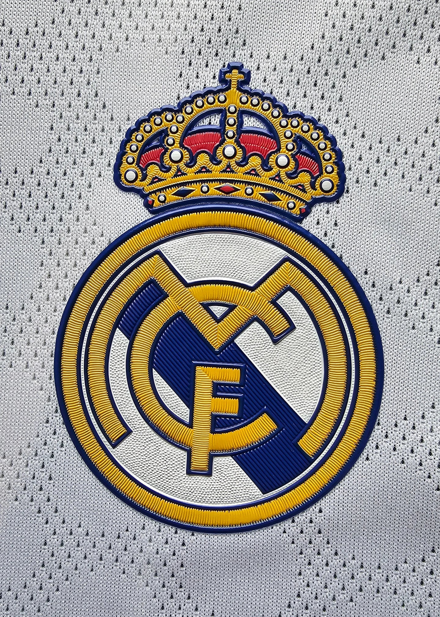 Crest detail featuring the Real Madrid CF logo with a crown and vibrant embroidery.