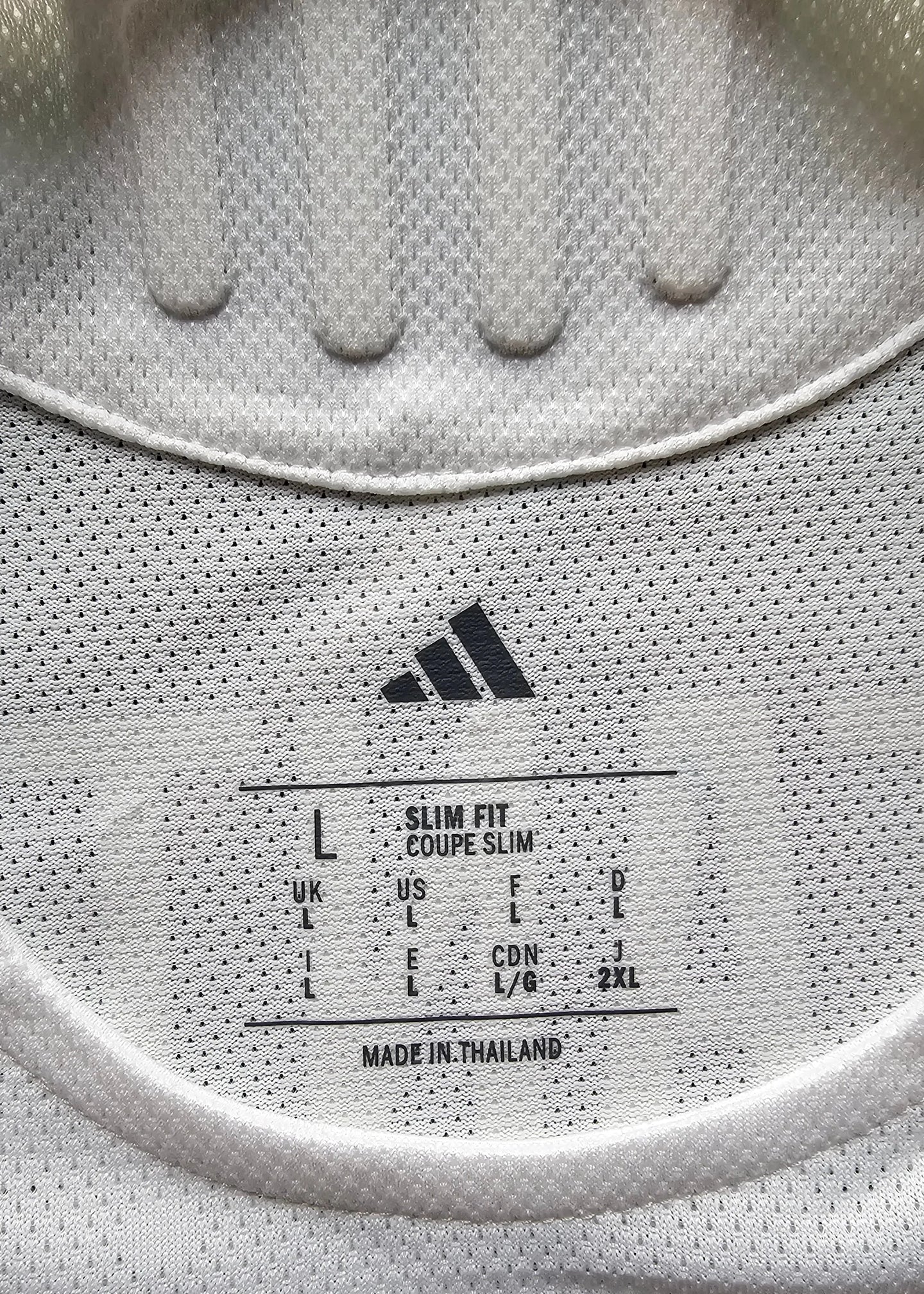 Size label showing L, slim fit with care instructions; adidas logo visible.