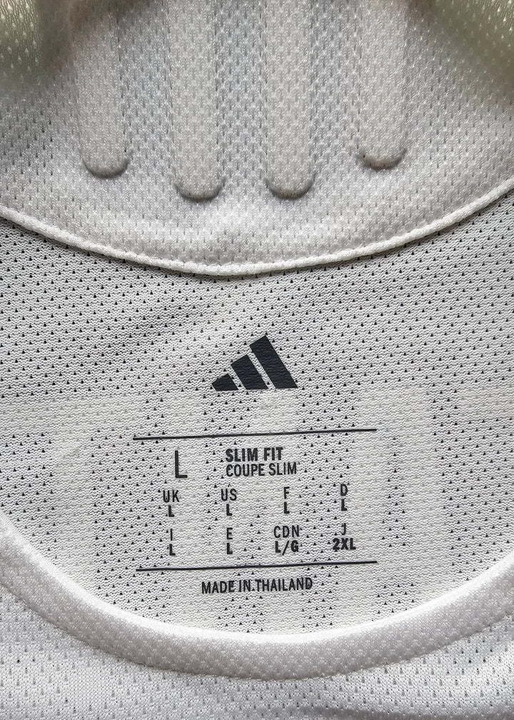 Size label showing L, slim fit; adidas logo visible with care instructions.