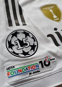 Detail view showing UEFA Foundation for Children logo, 10 years, and Champions League logo with No. 15.