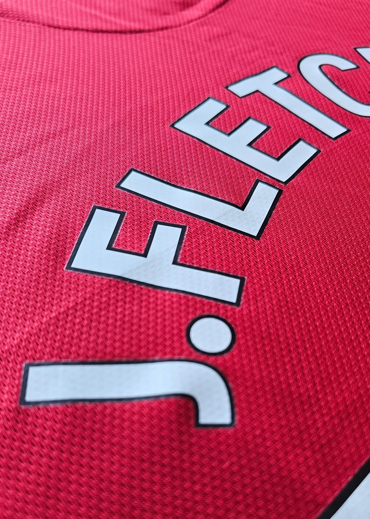 Close-up view of the name 'Fletcher' with a signature detail on a red football shirt.
