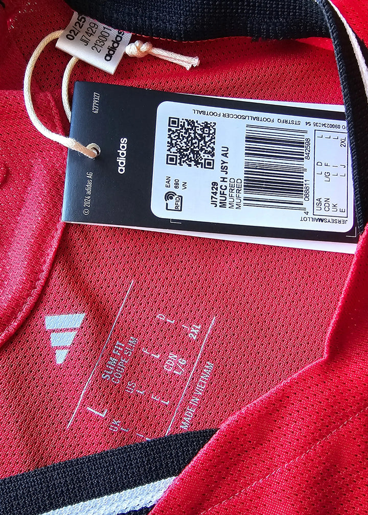 Internal label showing size L, care instructions, and adidas branding on red fabric.