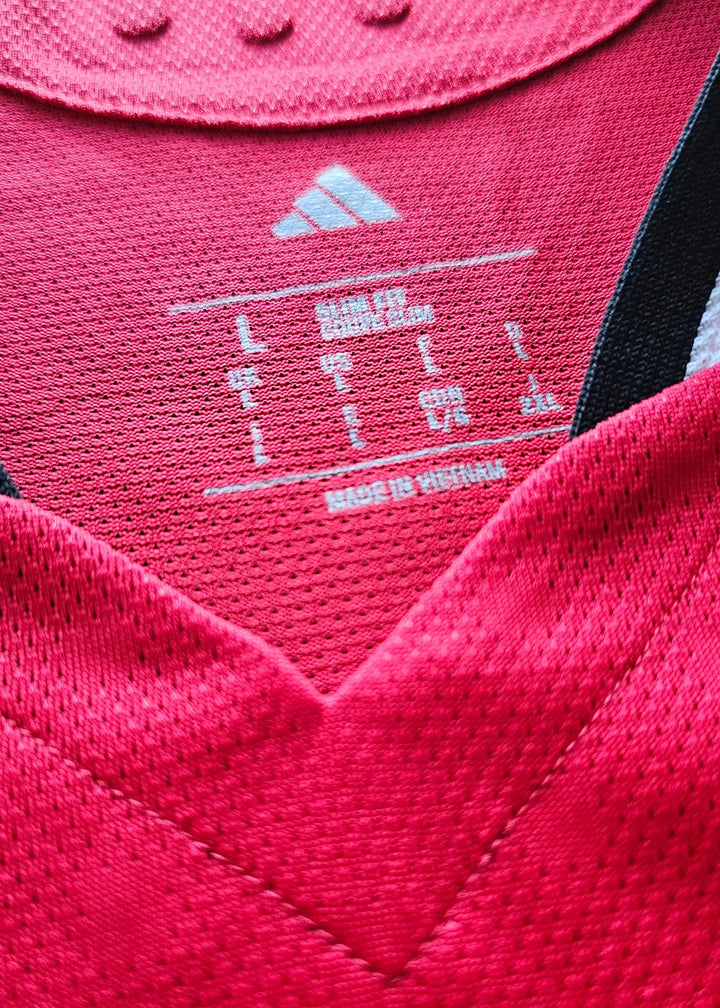 Size label showing L and "MADE IN VIETNAM" on red football shirt with adidas logo.