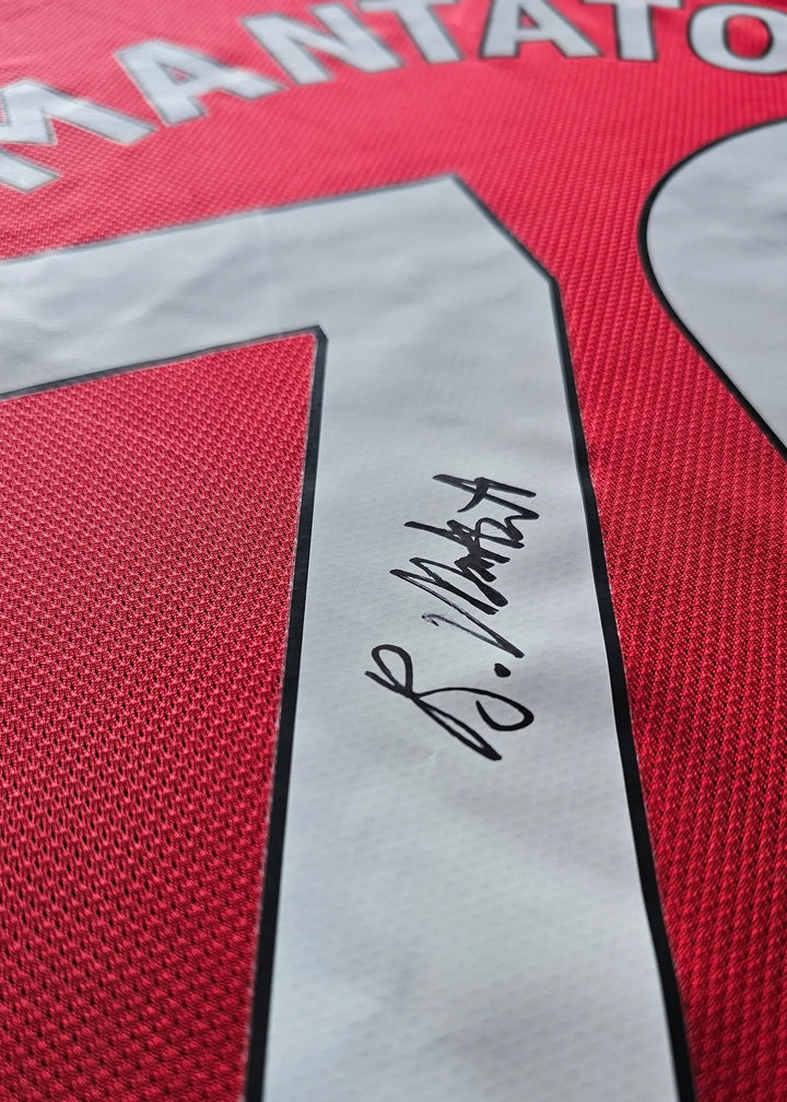 Back view showing No. 70 and Bendito Mantato's signature on the red football shirt.