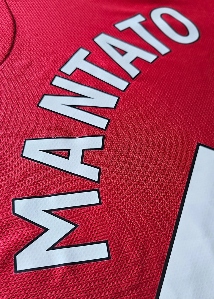 Close-up detail of the name 'MANTATO' in white lettering on a red football shirt.