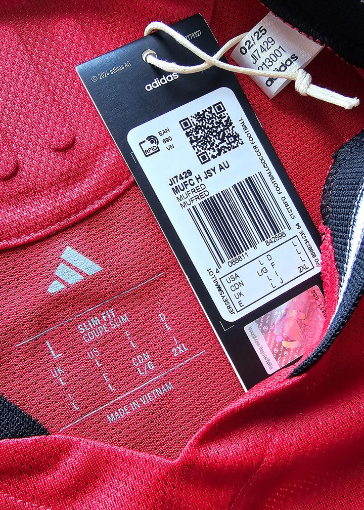 Label detail showing size information and adidas branding on a red football shirt.